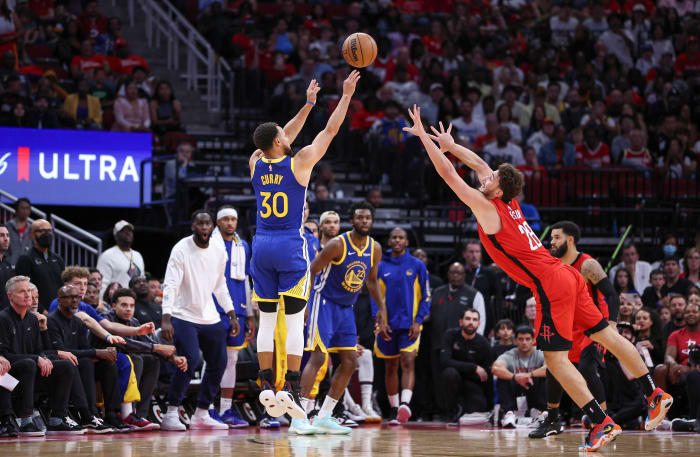 Warriors guard Stephen Curry shoots the ball as Houston Rockets center Alperen Sengun defends during the fourth quarter at Toyota Center.